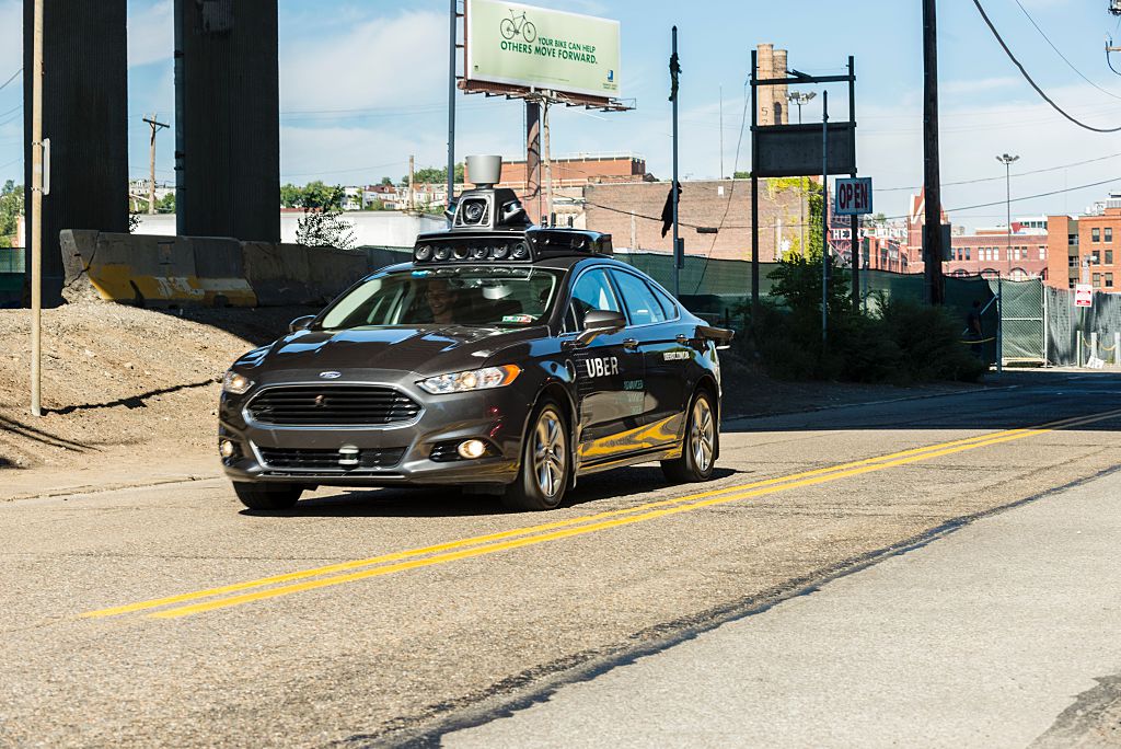 A passenger look on as he rides in a pilot model of an Uber self-driving car