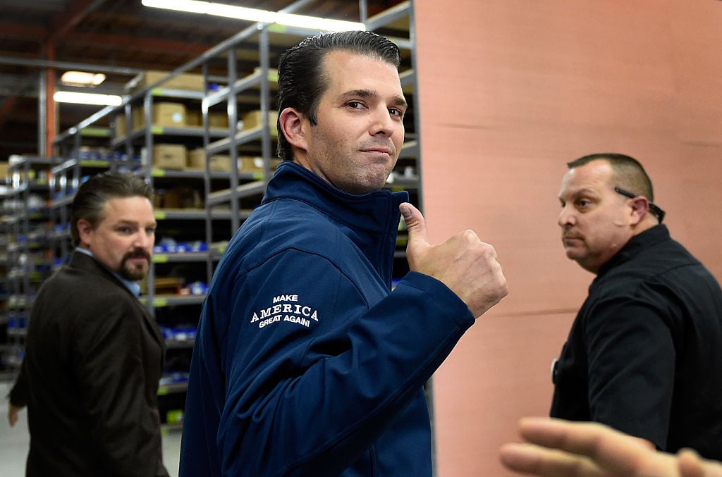 donald trump jr in a blue jacket giving the thumbs up sign