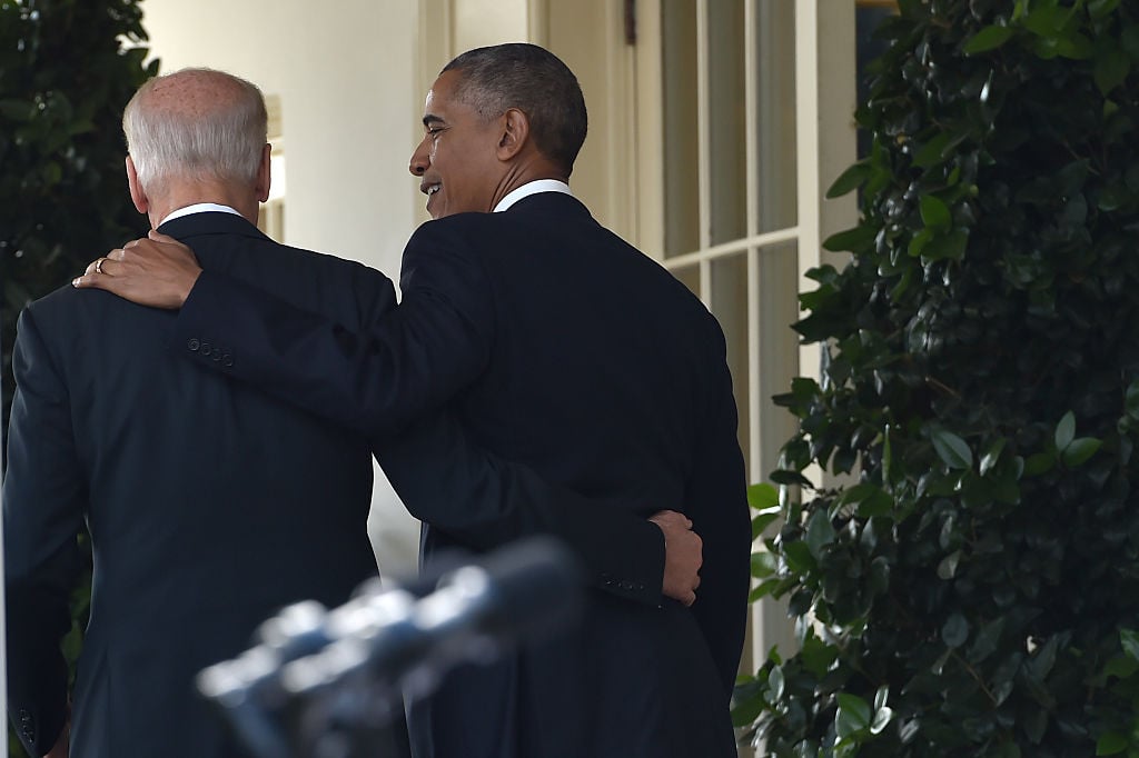 barack obama and joe biden walk in the white house, arm in arm, from behind barack obama and joe biden walk in the white house, arm in arm, from behind