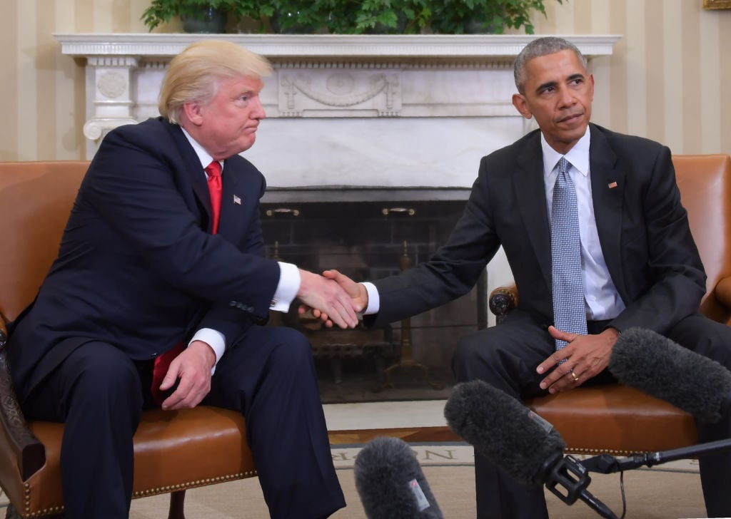 Trump and Obama shake hands.