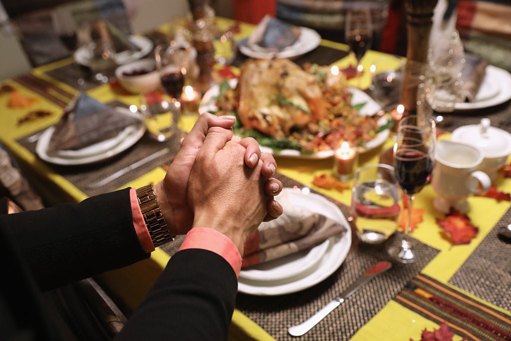 Central American immigrants and their families pray before Thanksgiving dinner
