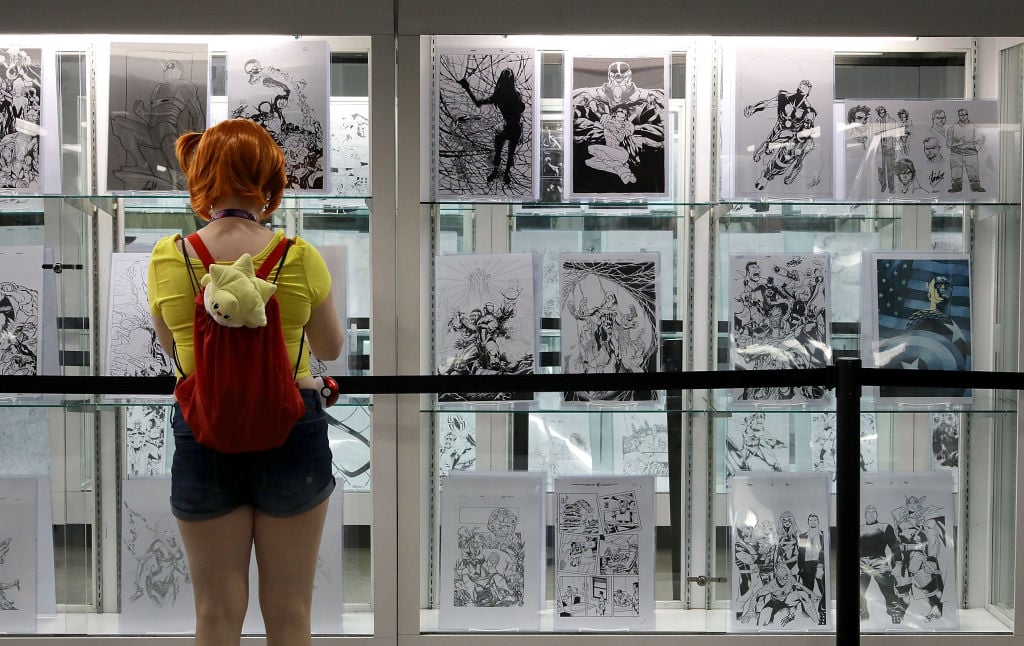 a girl in front of a black and white wall of comics a girl in front of a black and white wall of comics