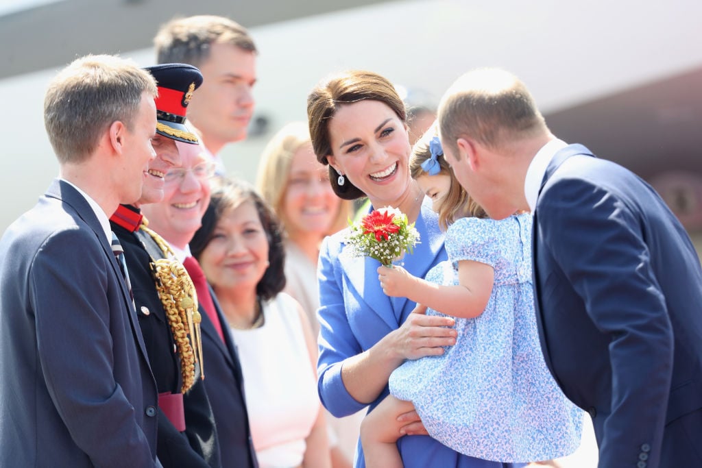kate middleton and her daughter charlotte surrounded by officials