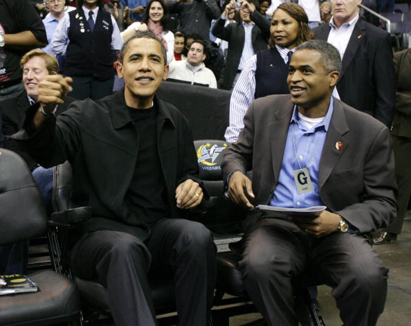 barack obama and marty nesbitt, both in black, watch a basketball game barack obama and marty nesbitt, both in black, watch a basketball game