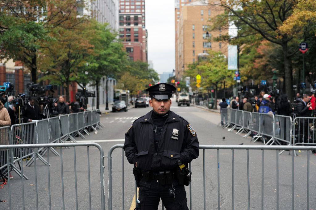 a police officer in front of a barricade in NYC a police officer in front of a barricade in NYC