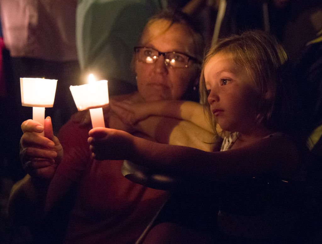 a child and a woman at a candlelight vigil in sutherland springs, texas a child and a woman at a candlelight vigil in sutherland springs, texas