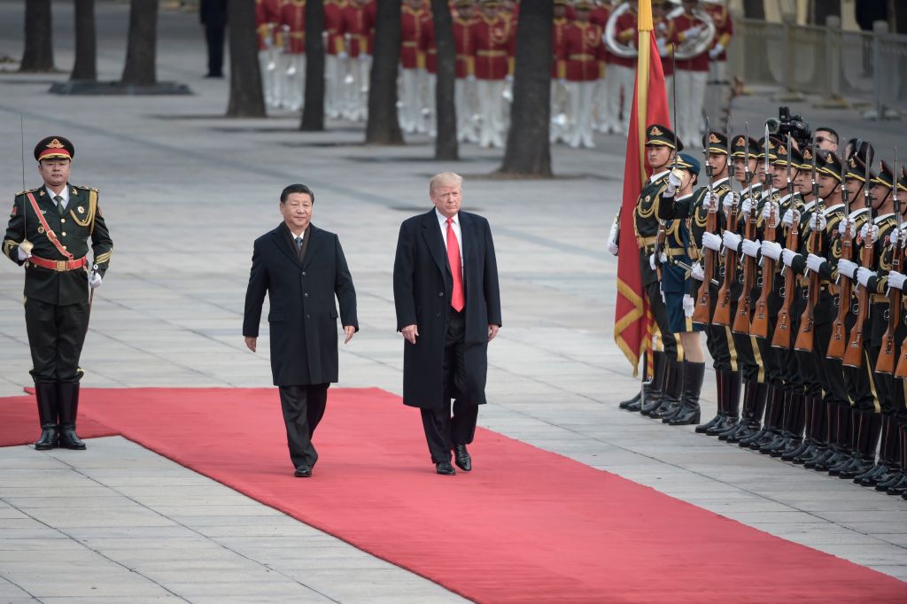 China's President Xi Jinping (2nd L) and US President Donald Trump review Chinese honour guards during a welcome ceremony at the Great Hall of the People in Beijing