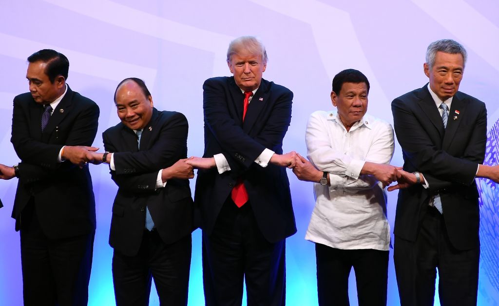 the asian leaders and trump grasp hands for a photo