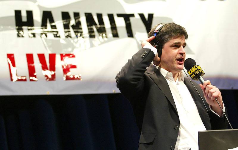 Sean Hannity speaking into a microphone while wearing a headset.