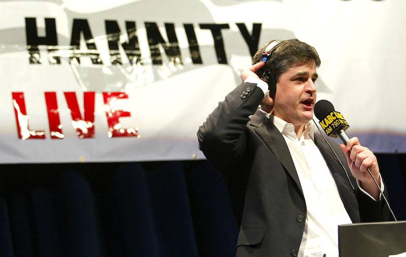 Sean Hannity speaking into a microphone while wearing a headset. Sean Hannity speaking into a microphone while wearing a headset.
