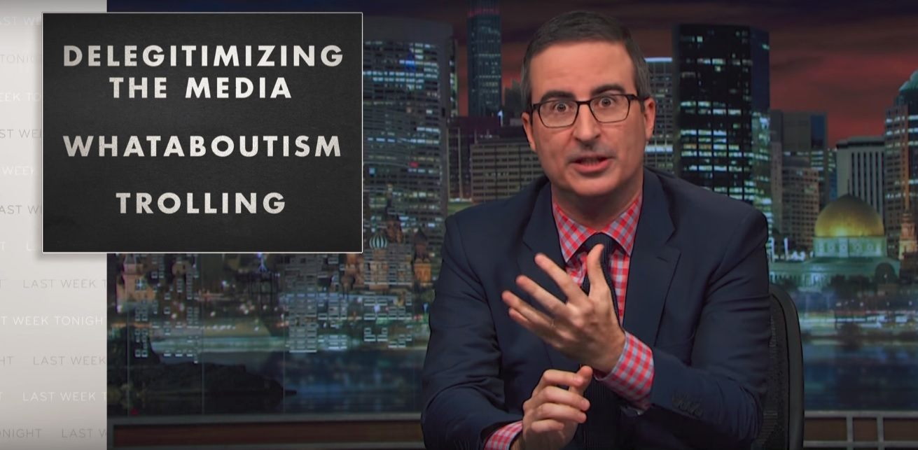 Jon Oliver sits at his desk talking about Trump Jon Oliver sits at his desk talking about Trump