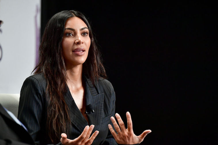 Kim Kardashian speaks in stage while wearing a black blazer. Kim Kardashian speaks in stage while wearing a black blazer.