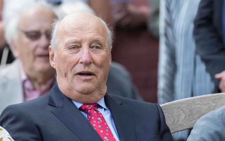 King Harald of Norway watches a presentation while sitting in an audience. 