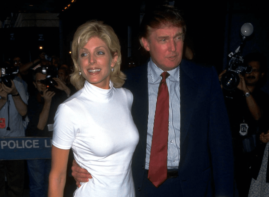 Marla Maples and Donald Trump posing in front of photographers. 