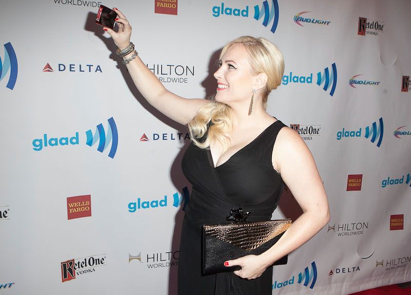 Meghan McCain taking a selfie on a red carpet while wearing a black dress and holding a clutch. Meghan McCain taking a selfie on a red carpet while wearing a black dress and holding a clutch.