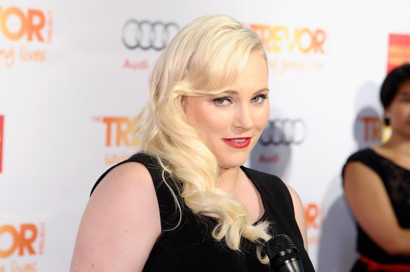 Meghan McCain posing for photographers at a red carpet in a black gown.