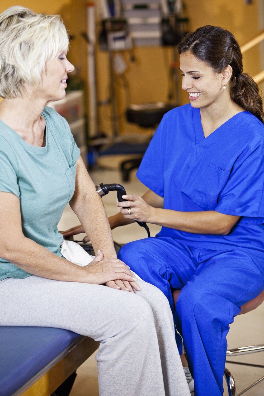 Physical therapist massaging a patient using device
