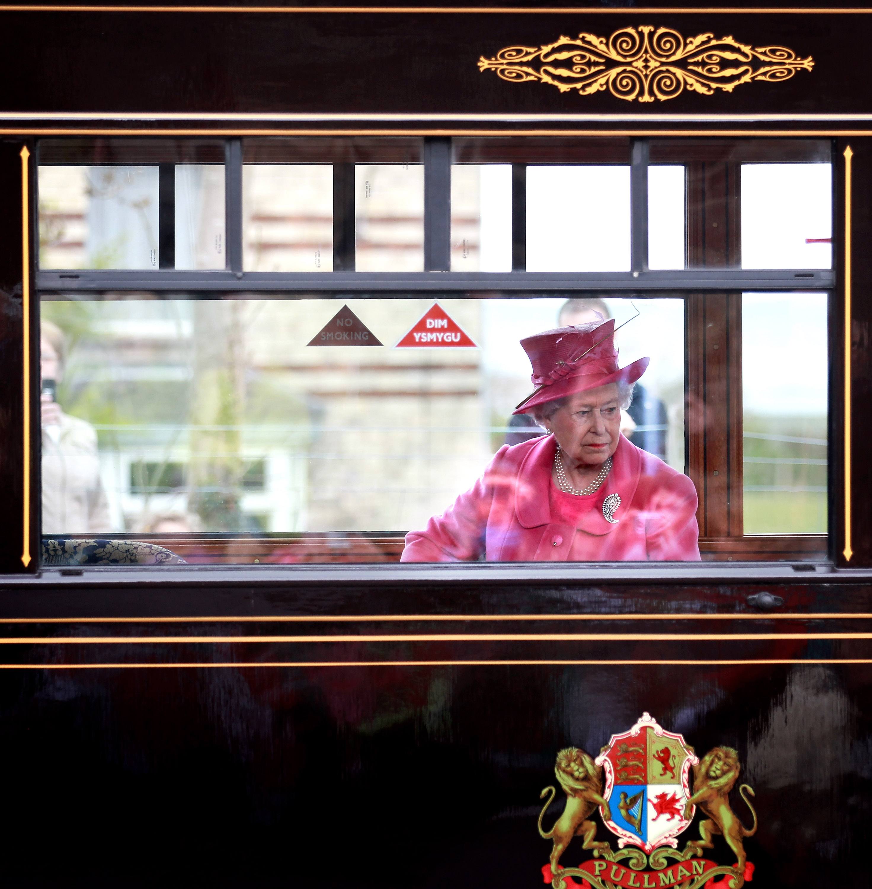 Queen Elizabeth riding a train.