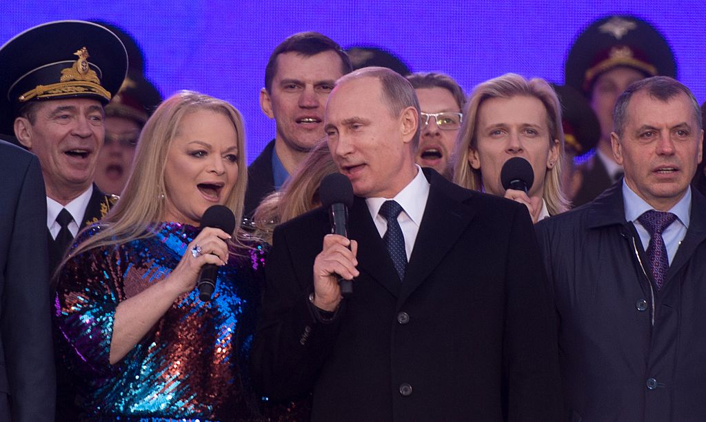 Russia's President Vladimir Putin (C), Russian pop singer Larisa Dolina (2ndL) and Crimean parliament speaker Vladimir Konstantinov (R) sing the Russian national anthem