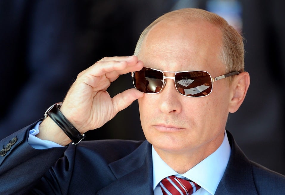 Russian Prime Minister Vladimir Putin adjusts his sunglasses as he watches an air show