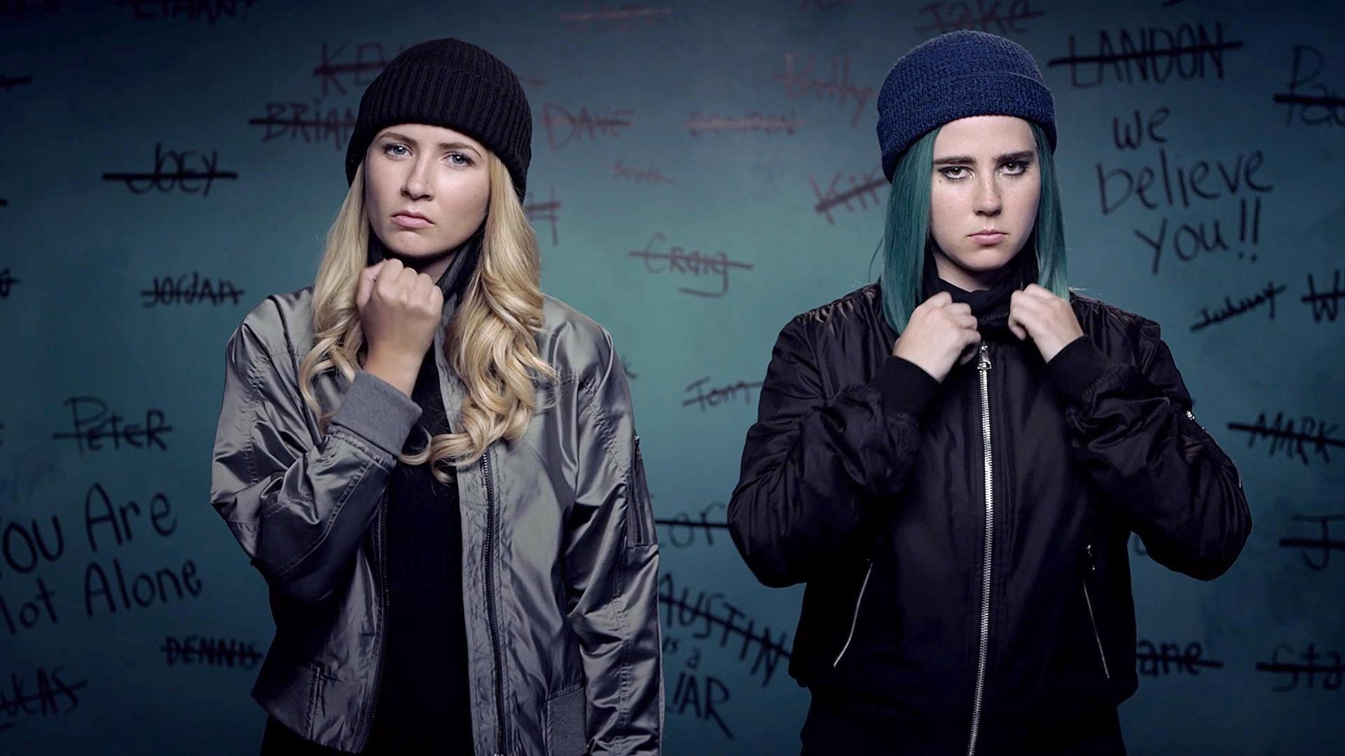 Two girls in beanies stand next to each other