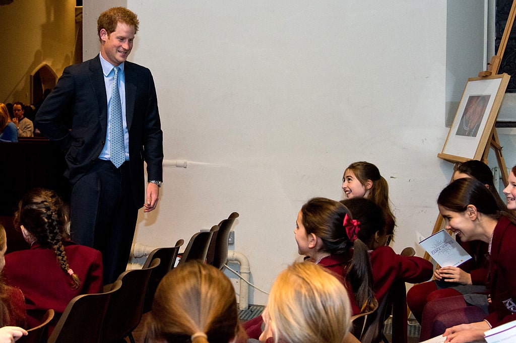 Prince Harry interacts with children in a choir. 