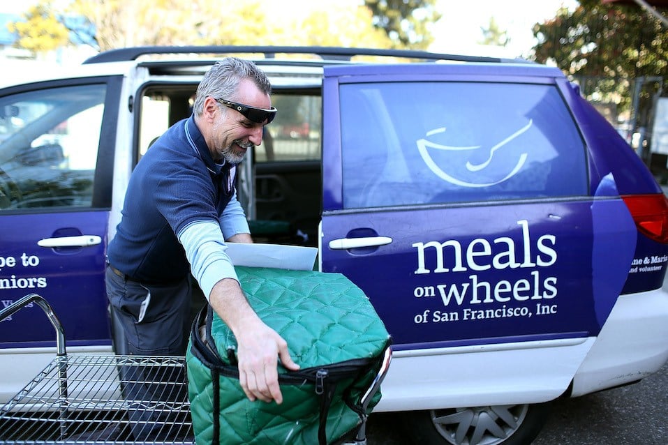 Meals On Wheels of San Francisco driver Jim Fleming loads meals into a van