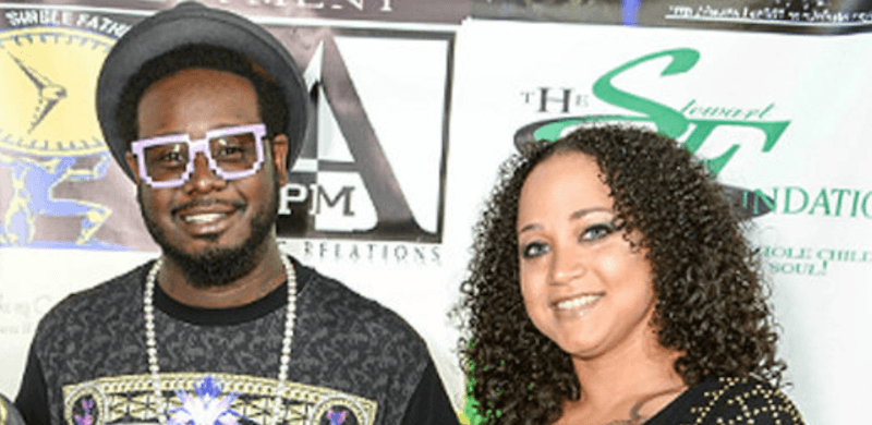 T-Pain and Amber Najm smile at a red carpet event.