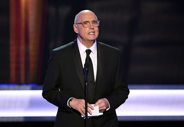 Jeffrey Tambor speaking in a suit in front of a microphone on stage. Jeffrey Tambor speaking in a suit in front of a microphone on stage.