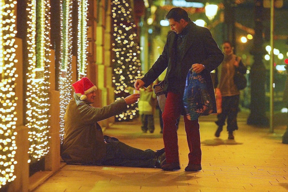 A man gives a homeless person some money in the street A man gives a homeless person some money in the street