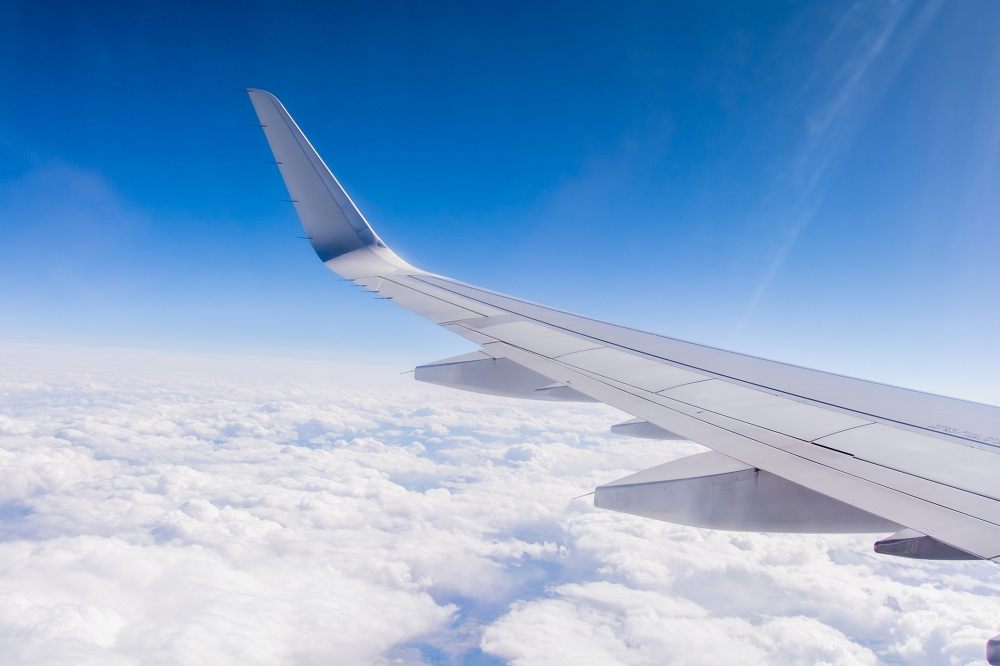 Airplane wing in sky & clouds