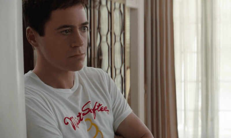 Young Tony Stark leans against a white wall inside a house. Young Tony Stark leans against a white wall inside a house.