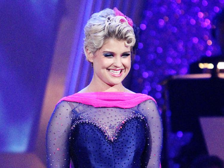 Kelly Osbourne stands in a blue outfit on Dancing With the Stars