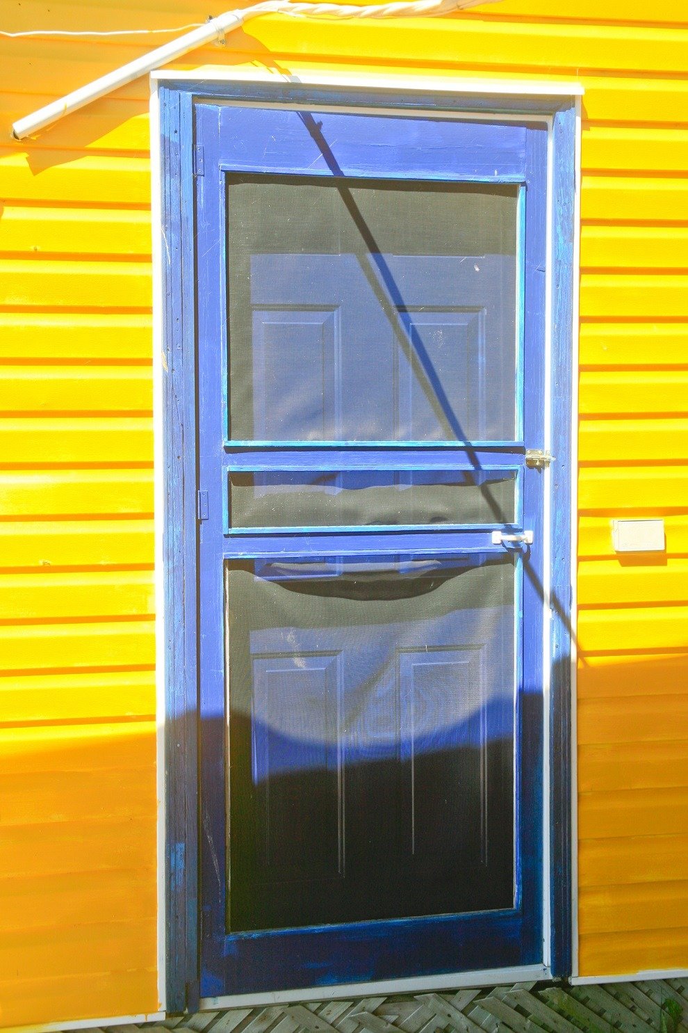 Blue screen door and yellow house