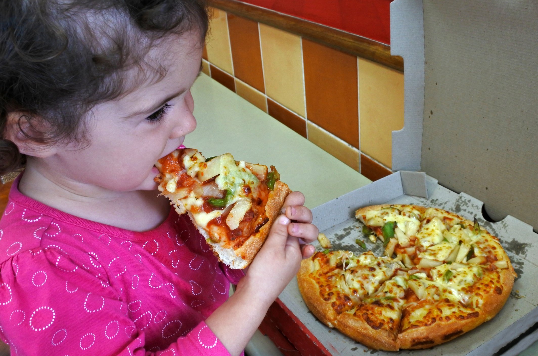 Little girl eating pizza