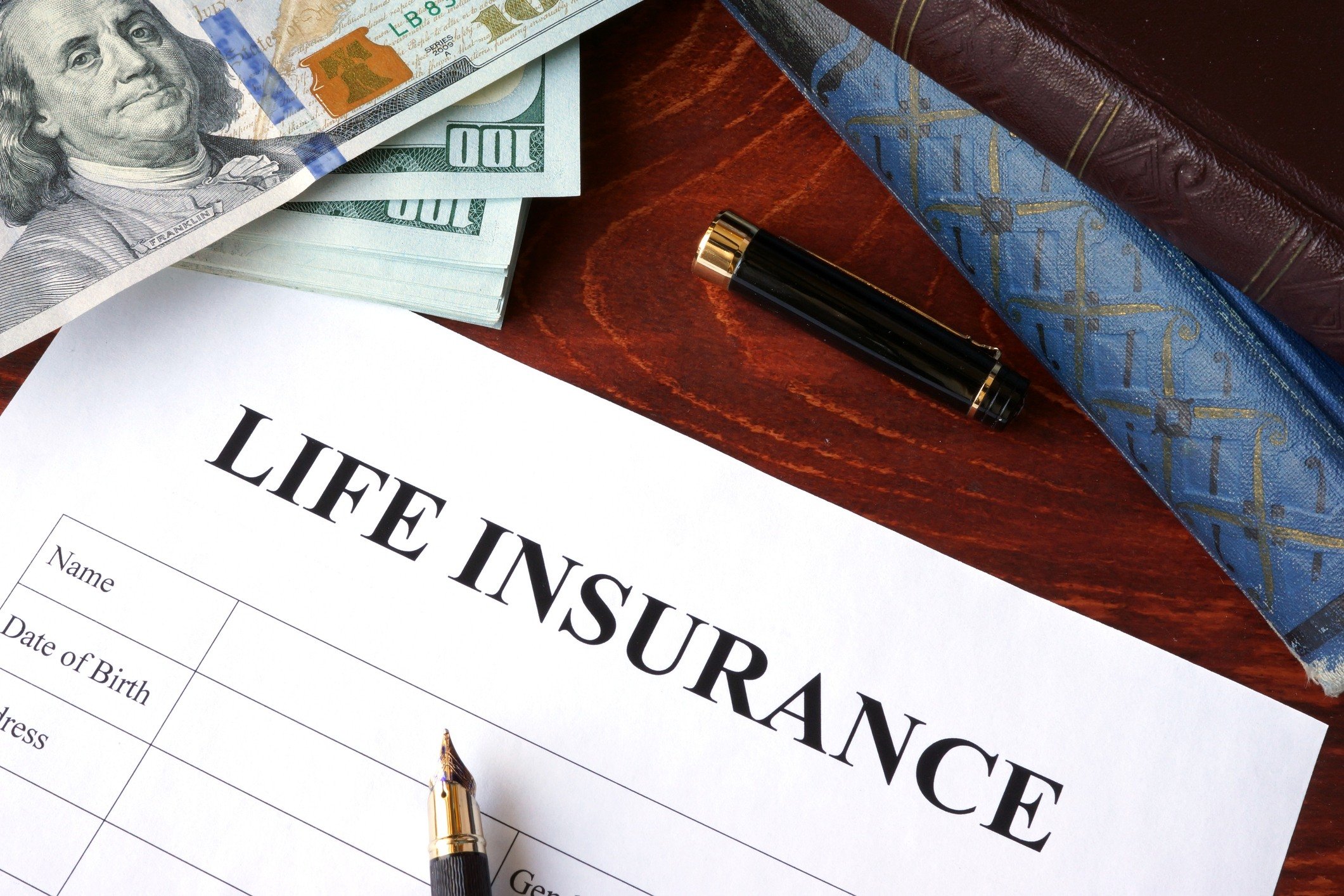 Life insurance policy and currency on a table.