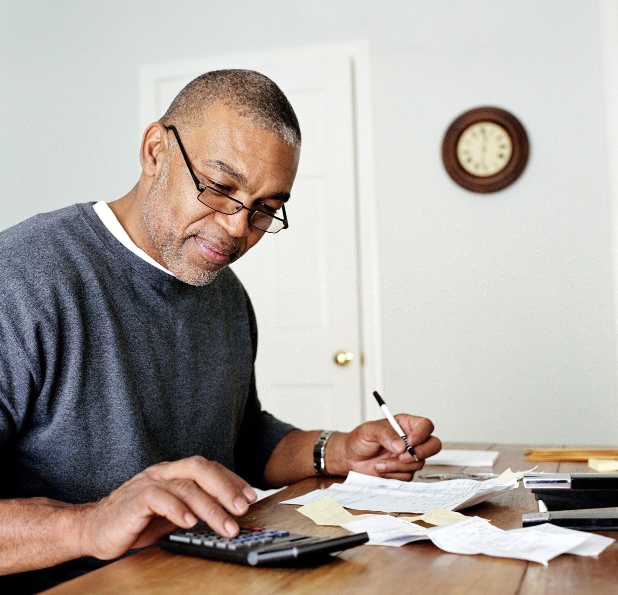 Mature man doing finances in home office Mature man doing finances in home office