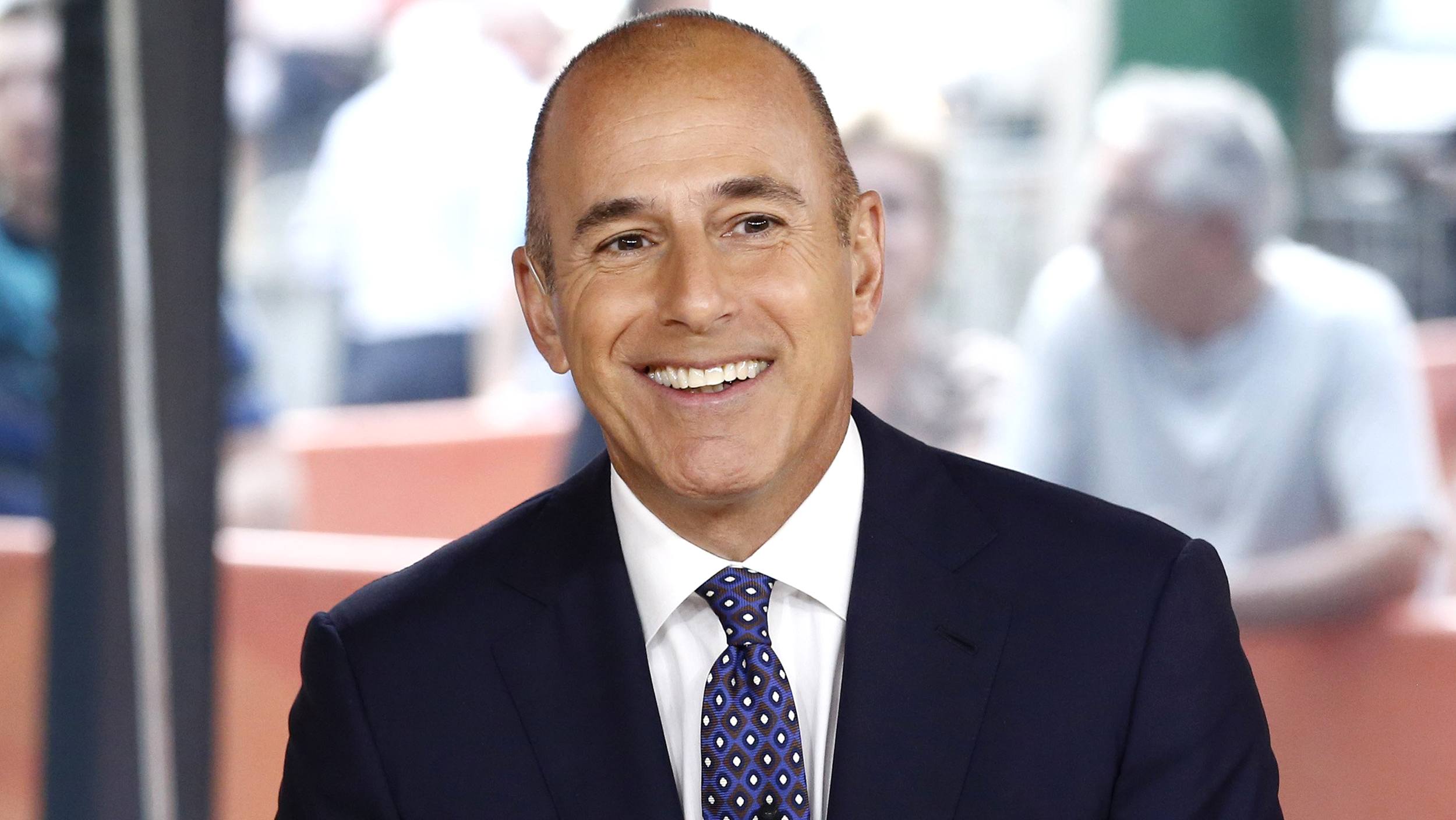 matt lauer smiles on set of Today in a dark suit and speckled tie