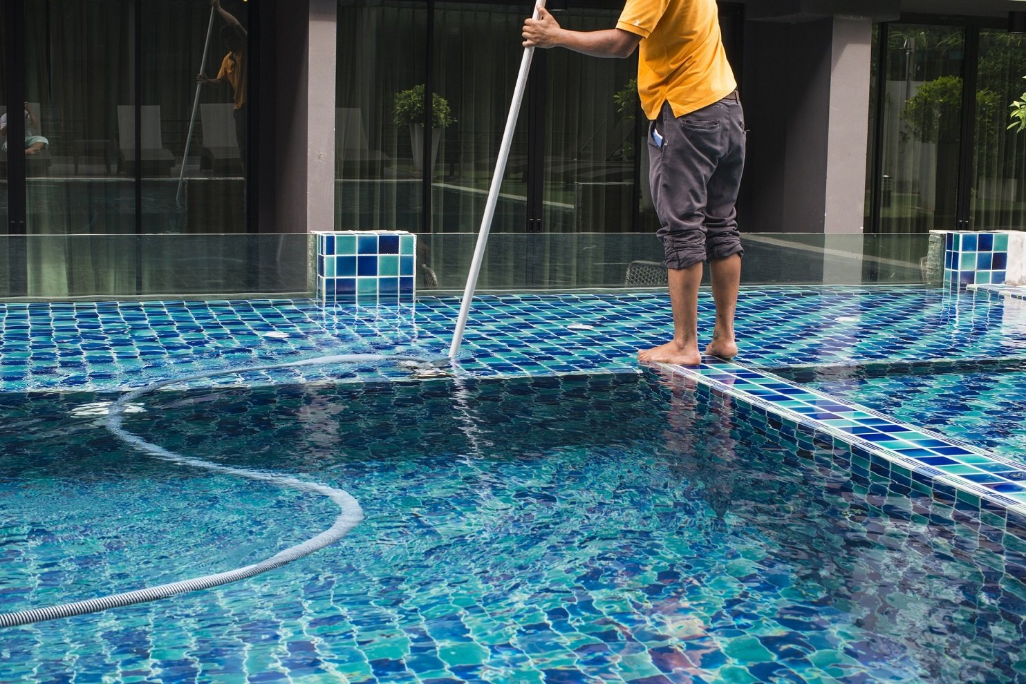 Man cleans a pool