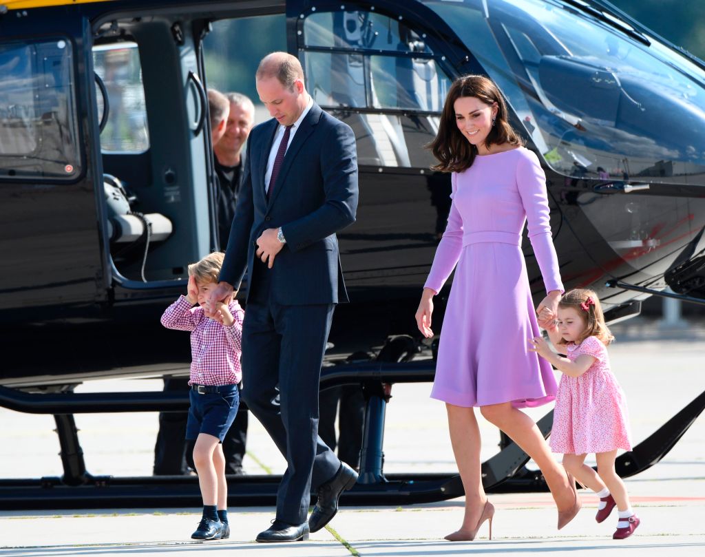 Prince William and Kate Middleton walking near a helicopter. 