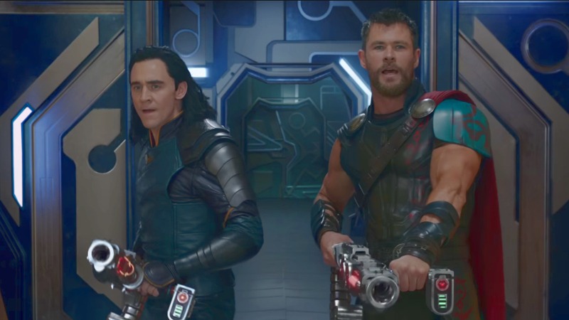 Thor and Loki hold up weapons
