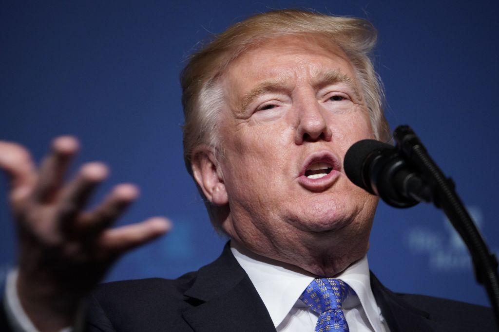 Donald Trump speaking into a microphone. Donald Trump speaking into a microphone.