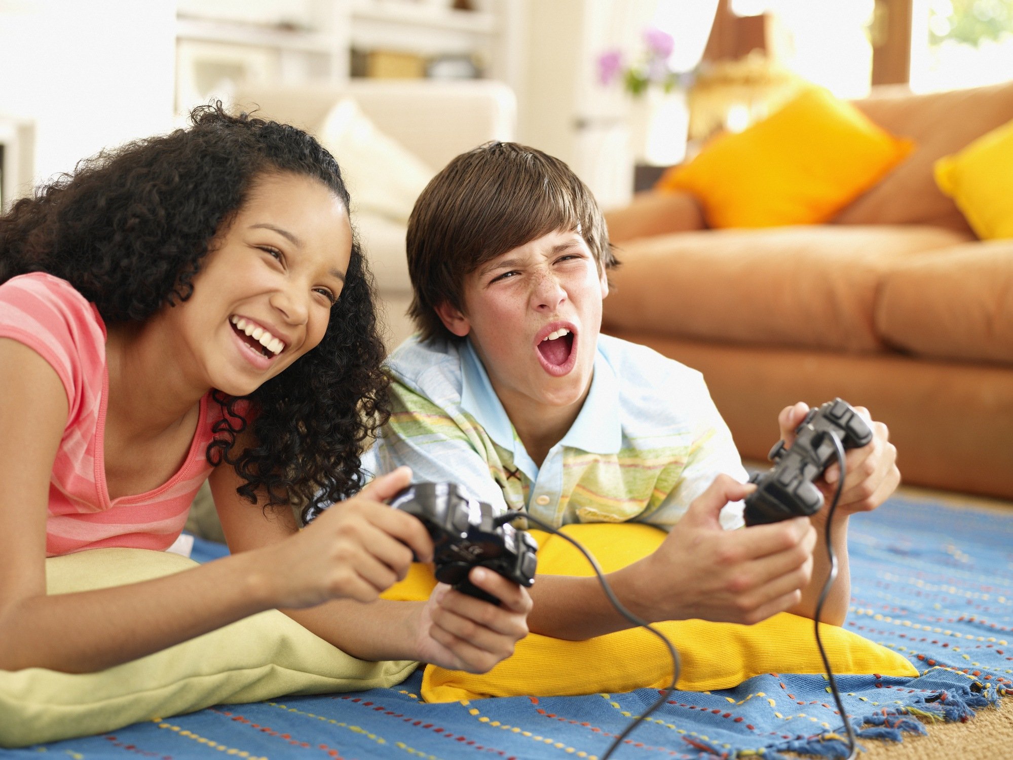 Teenage girl and boy playing video games