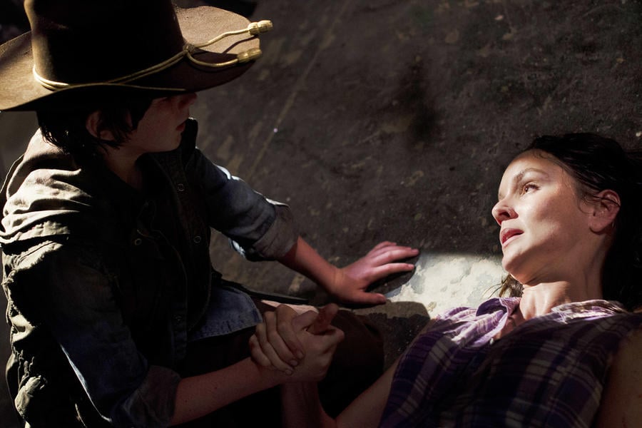 Carl holds the hand of his dying mom