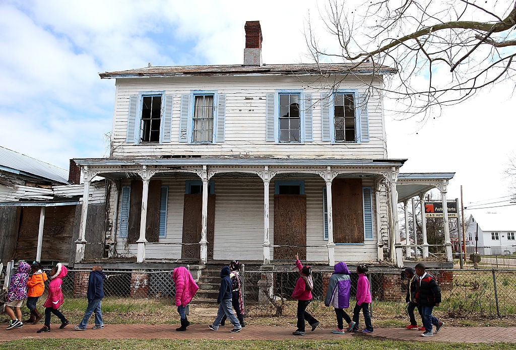 School kids walk by a vacant home that is along the historic route that civil rights marchers took during the Selma to Montgomery march