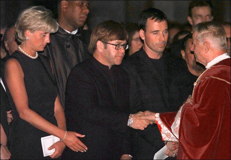 Archpriest Magio (R) shakes hands with British rock star Elton John standing next to Princess Diana (L) during the requiem mass for Italian fashion designer Gianni Versace