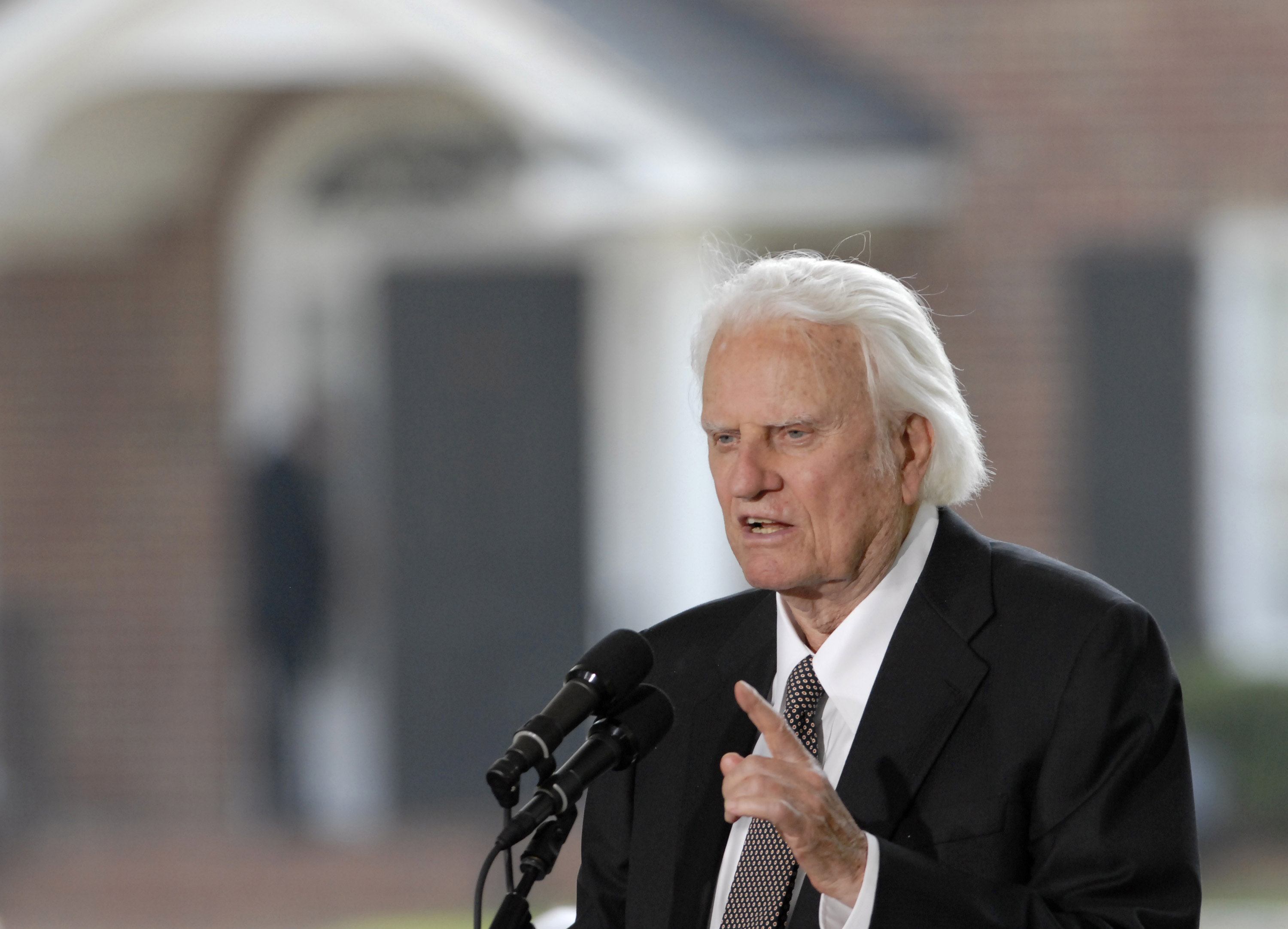 Evangelist Billy Graham speaks into microphone