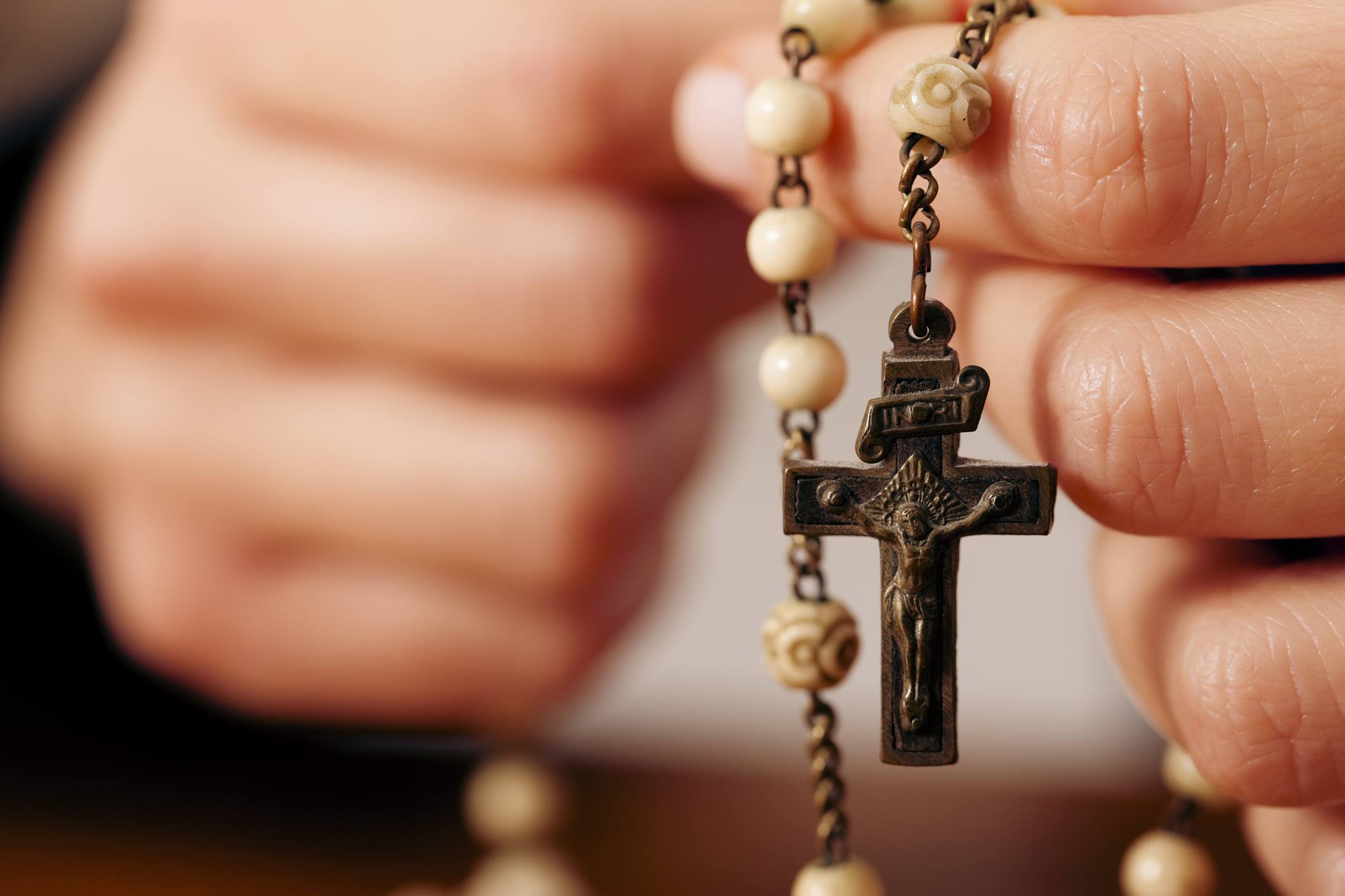 Woman praying with rosary to God Closeup Woman praying with rosary to God