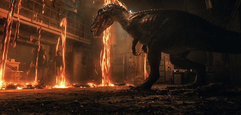 A dinosaur approaches Claire and another man as they hide from fire. A dinosaur approaches Claire and another man as they hide from fire.