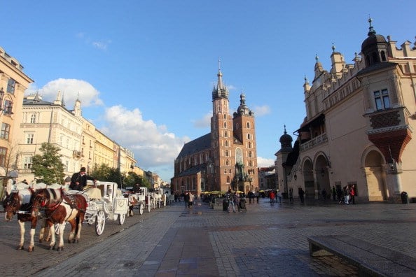 a basilica in the street in poland with a horse-drawn carriage a basilica in the street in poland with a horse-drawn carriage